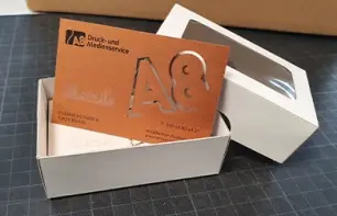 Visitenkarte mit Lasercut in einer offenen Schachtel